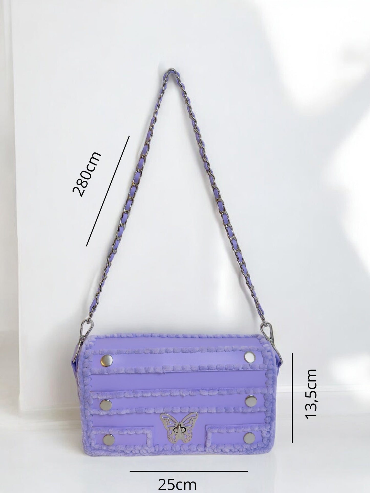 purple handbag with chain and butterfly ornament.