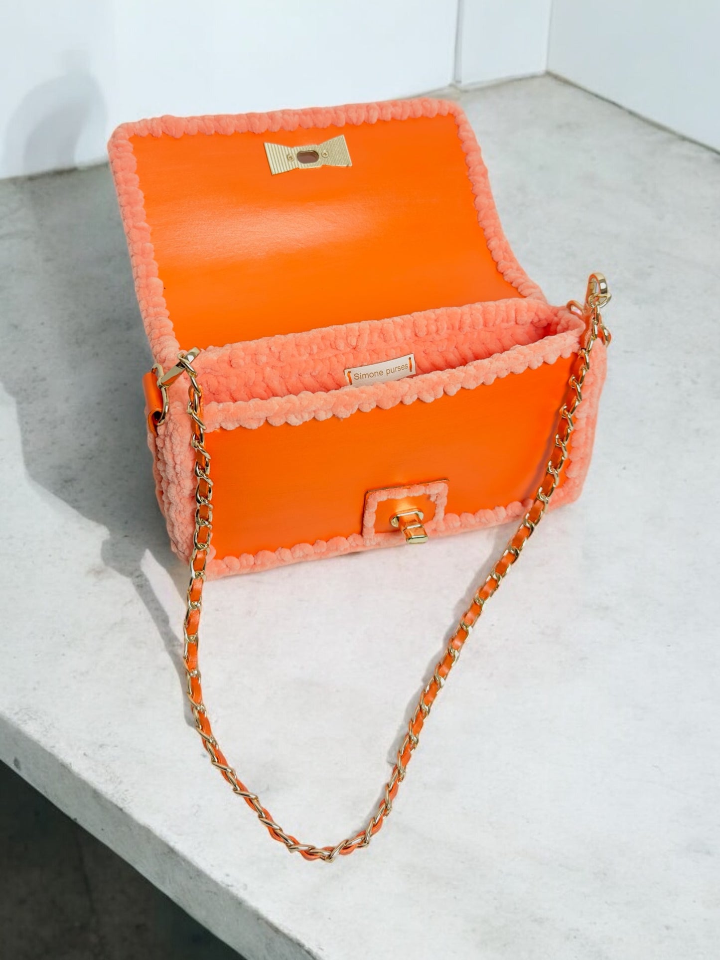 Orange metallic handbag with gold chain