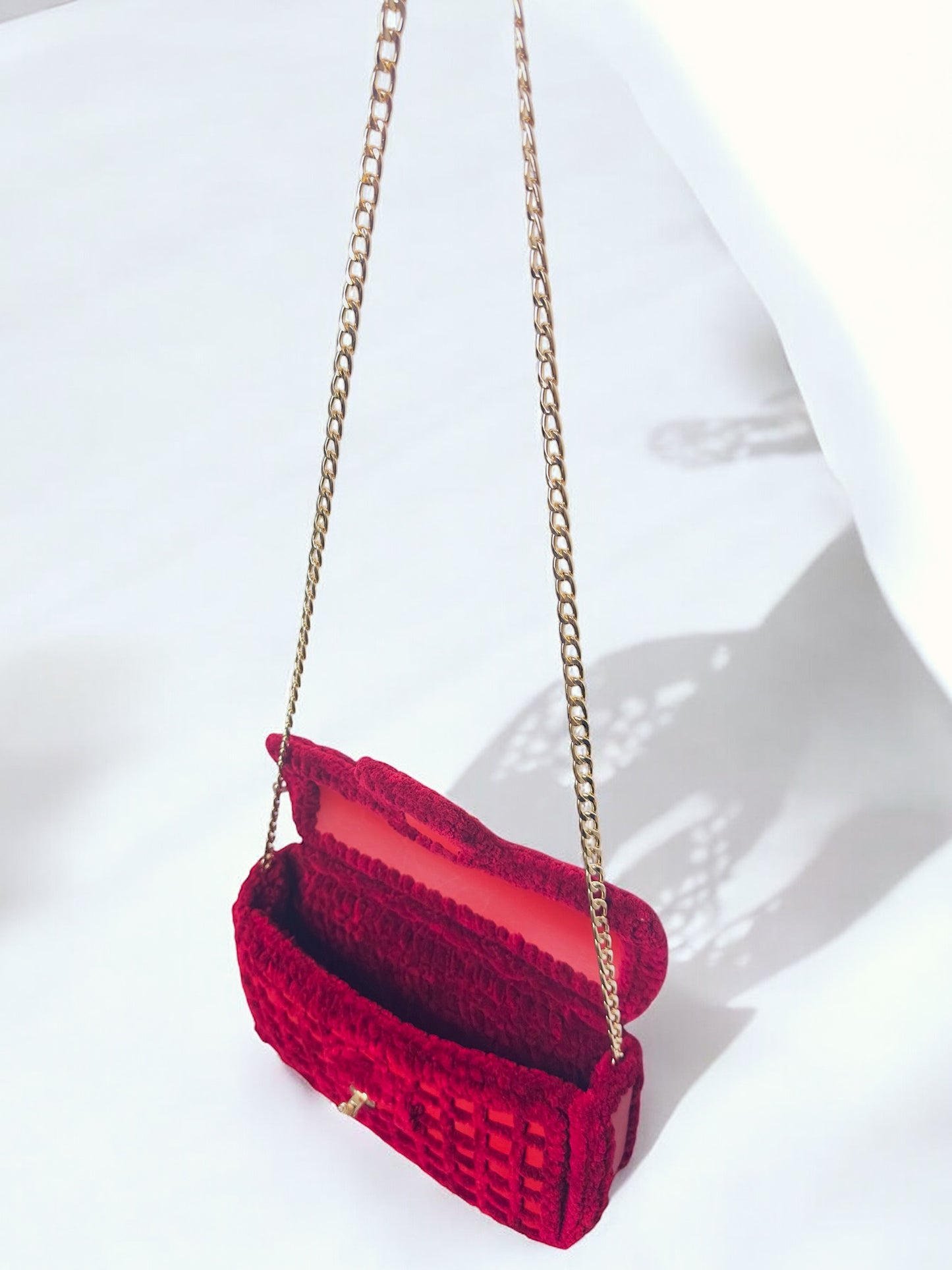 red mesh handbag with gold chain and bee ornament