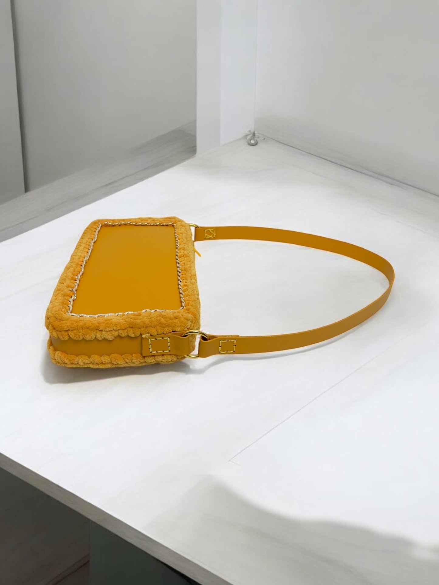 Yellow handbag with golden chain and braided wool borders