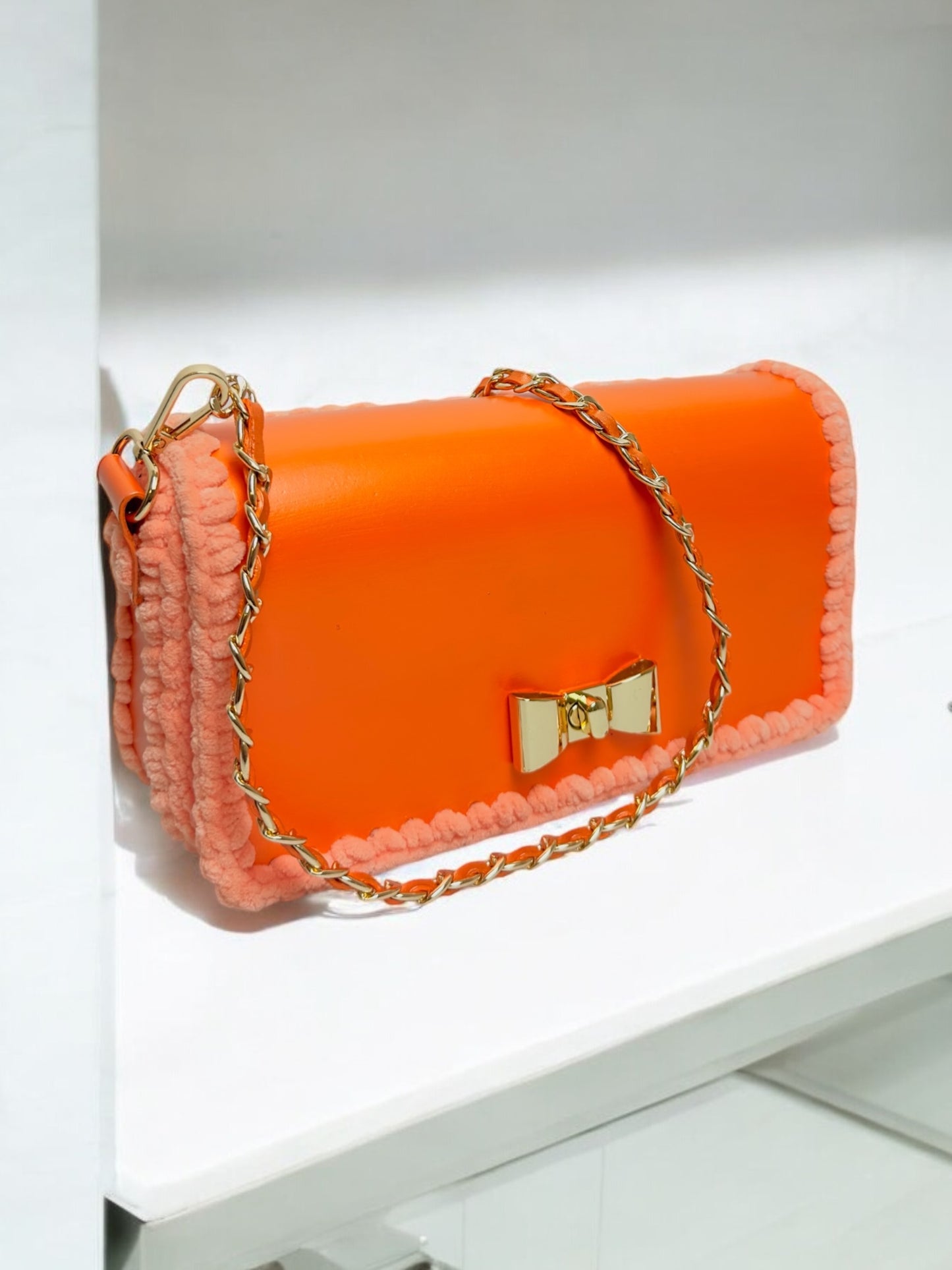 Orange metallic handbag with gold chain